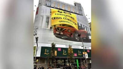 Un grupo de activictas de Greenpeace se han encaramado este viernes a la fachada de un edificio comercial de la Gran Vía madrileña, donde han desplegado una pancarta de 180 metros cuadrados para denunciar la 'fiesta del consumismo' en el Black Friday o Viernes Negro y su relación con la crisis climática.