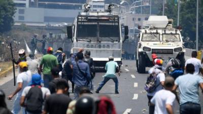 Opposition demonstrators clash with soldiers loyal to Venezuelan President Nicolas Maduro after troops joined opposition leader Juan Guaido in his campaign to oust Maduro's government, in the surroundings of La Carlota military base in Caracas on April 30, 2019. - Guaido -- accused by the government of attempting a coup Tuesday -- said there was 'no turning back' in his attempt to oust President Nicolas Maduro from power. (Photo by Federico PARRA / AFP)