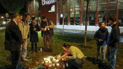 Familiares, amigos y compañeros de las víctimas ponen ofrendas florales en uno de los sitios se cometió el crimen.