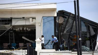 Tres hombres inspeccionaron los daños desde el techo de un restaurante en el Hotel Kingsbury en Colombo, un día después de que el hotel fue alcanzado en una serie de explosiones de bombas en iglesias y hoteles de lujo en Sri Lanka. Foto AFP