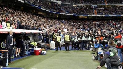 Gran número de fotógrafos y cámaras de video, siguiendo el debut del nuevo técnico francés del Real Madrid, Zinedine Zidane (i), antes del inicio del encuentro contra el Deportivo La Coruña en el estadio Santiago Bernabéu. Foto EFE