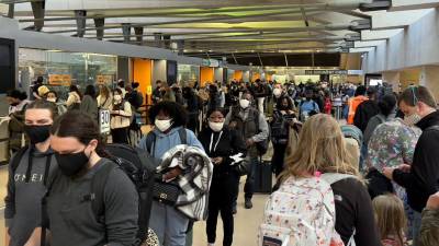 Los viajeros de vacaciones transitan por el aeropuerto internacional en Dulles, Virginia.