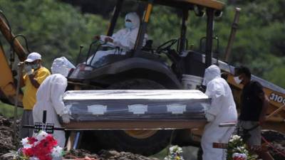 Un grupo de personas participa en un entierro en el cementerio Jardín de Paz Los Ángeles, destinado para entierros de personas que fallecen por el coronavirus, al este de Tegucigalpa. Foto EFE