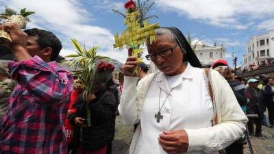 Ciudadanos ecuatorianos participan en una ceremonia con arreglos florales en las afueras del templo en el centro histórico en Quito. Foto EFE