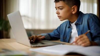 Imagen ilustrativa de un niño recibiendo clases de manera virtual.