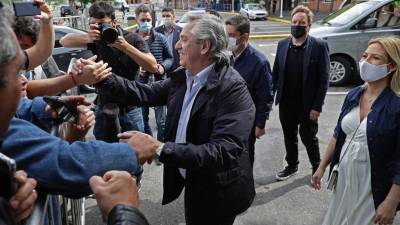 El presidente de Argentina, Alberto Fernández , acompañado de su esposa embarazada, Fabiola Yáñez, saluda a los simpatizantes después de emitir su voto en un colegio electoral.