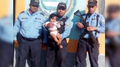 La menor es custodiada por tres agentes de la Policía Nacional de Honduras en una fotografía tomada en Santa Bárbara, zona occidente del país.