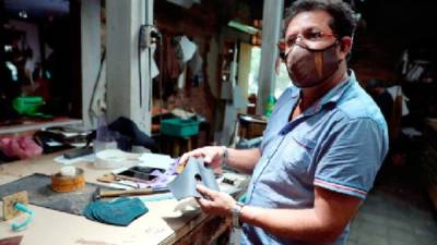 El artesano Rubén Gonzales elabora tapabocas en cuero en el municipio Valle de Ángeles.