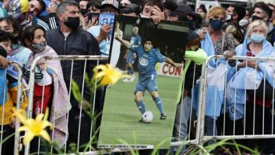 La gente hace fila frente al palacio presidencial en Buenos Aires para rendir homenaje al ataúd de la leyenda del fútbol Diego Maradona, que llegó durante un período de reposo tras su muerte el día antes de los 60 años mientras se recuperaba de una operación. Foto AFP