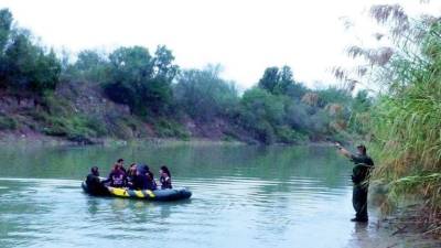 El agente de la Patrulla Fronteriza de EE.UU. Isaac Villegas le ordena a un grupo de balseros centroamericanos que regresen al lado mexicano de la frontera.
