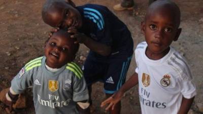 Niños africanos lucen camisetas donadas por el equipo blanco.