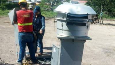 Técnicos de Cescco mientras revisan uno de los medidores ubicados en Tegucigalpa.