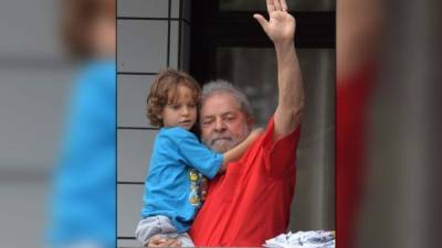 El expresidente Lula da Silva saludó a sus seguidores mientras carga a uno de sus nietos en Sao Bernardo do Campo. Foto: AFP /Nelson Almeida