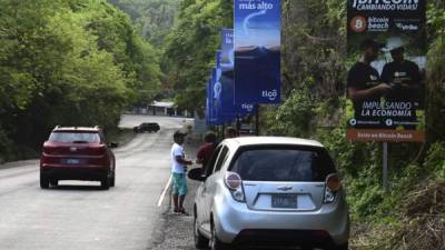 Una pancarta que ofrece bitcoins se ve en una carretera de El Zonte, 56 km al sureste de San Salvador, El Salvador. Foto AFP