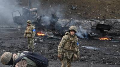 Soldados ucranianos inspeccionan una área afectada por los rusos.