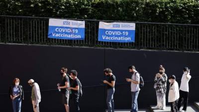 Un grupo de personas afuera para recibir la vacuna Pfizer-BioNTech covid-19 en un centro temporal en la Tate Modern, en el centro de Londres. Foto AFP