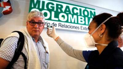 Funcionarios toman la temperatura de los ciudadanos que llegan al aeropuerto internacional El Dorado, como parte de la campaña de prevención y contención contra el coronavirus, el pasado 5 de marzo de 2020, en Bogotá (Colombia).