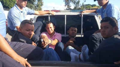 Agentes de la DPI cuando llevaban a los cuatro detenidos.