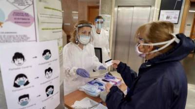 Trabajadores sanitarios del centro de salud de General Ricardos, en Madrid, atienden a una paciente.