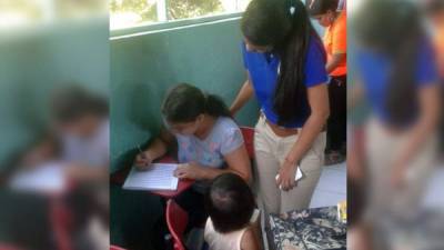 Una estudiante supervisa a su alfabetizada en el último día de clases; observa la hija de la beneficiada.