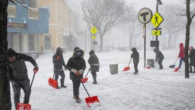 La gente palea fuera de la estación MBTA de Davis Square durante la tormenta de nieve en Somerville, Massachusetts.