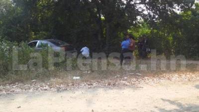 Escena del crimen en la que un hombre, después de haber sido sacado de su vehículo, fue ejecutado a balazos en la ciudad de San Pedro Sula.