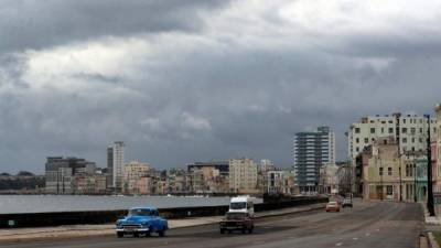 Fotografía de vehículos cruzando frente al malecón tras el paso de la tormenta tropical Elsa hoy, en La Habana (Cuba).