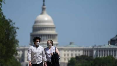 Dos personas se protegen con mascarillas en Washington DC. Foto: AFP