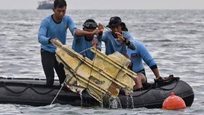 Buzos de la Armada de Indonesia retienen los restos del vuelo SJY182 de Sriwijaya Air durante una operación de búsqueda y rescate en el mar cerca de la isla Lancang. Foto AFP