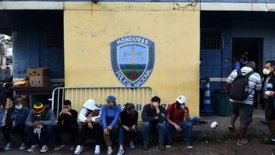 (Foto archivo) Los marineros hondureños que llegaron en las últimas horas al país esperan a que los miembros del Comité Permanente de Contingencia Hondureño (COPECO) hagan una prueba para detectar el nuevo coronavirus frente a una estación de policía en Tegucigalpa el 18 de marzo de 2020.