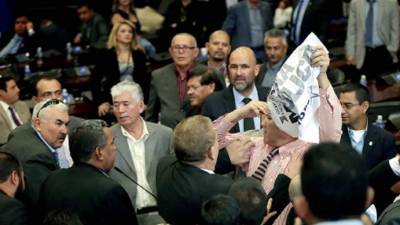 El diputado Luis Cruz arrodillado reclama voto público y estuvo a punto de irse a los puños con un miembro de la seguridad.