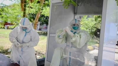 Un oficial médico prepara su equipo de protección antes de realizar pruebas para el coronavirus COVID-19 en un centro de cuarentena. Foto AFP