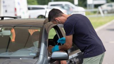 Un hombre permanece en su automóvil en el primer centro de vacunación de Berlín. Foto AFP