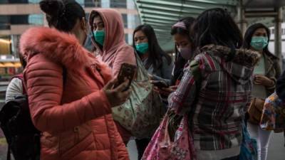 Mujeres con máscaras protectoras charlan en un puente en Hong Kong, como medida preventiva después de un brote de coronavirus que comenzó en Wuhan. Foto AFP