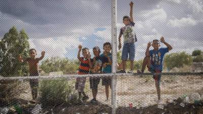 Fotografía que muestra un grupo de niños mexicanos que observan la construcción de un muro de acero en la localidad de Sunland Park, en Nuevo México (México).