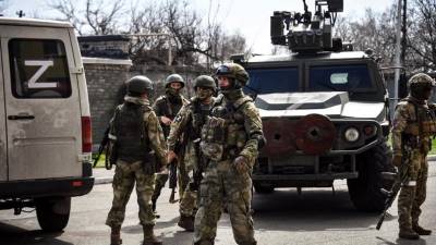 Soldados rusos patrullan una calle mientras continúa la invasión en Ucrania.