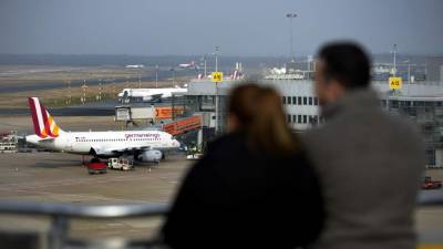 Dos pasajeros observan un avión de Germanwings, un Airbus igual al que se estrelló esta mañana en los Alpes franceses.