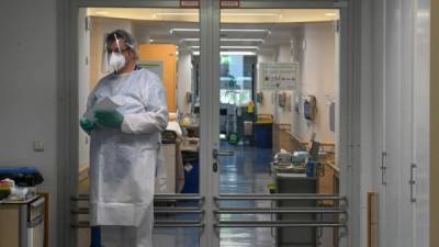 Un médico se para frente a la entrada de una unidad de cuidados intensivos en un hospital en Gauting cerca de Munich. Foto AFP