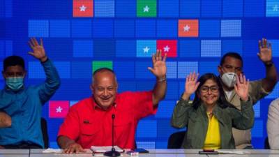 El líder del Partido Socialista Unido de Venezuela (PSUV), Diosdado Cabello (2a izquierda), reacciona mientras escucha los resultados de las elecciones legislativas junto a la vicepresidenta de Venezuela, Delcy Rodríguez (derecha) en Caracas.Foto AFP