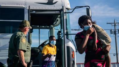 Los migrantes salen de un autobús de la Patrulla Fronteriza y se preparan para ser recibidos por la Coalición Humanitaria Val Verde después de cruzar el río Bravo.