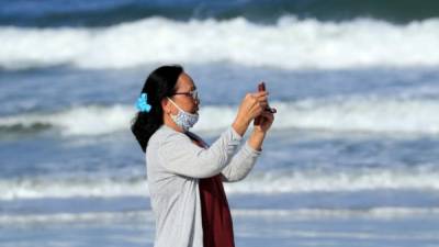 Una mujer toma una fotografía en las playas de Jacksonville. Foto: AFP
