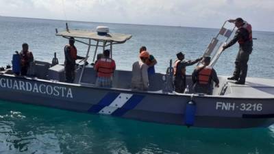 Elementos de Bomberos y la Fuerza Naval mientras trasladaban a tierra al fallecido, aún con vida.