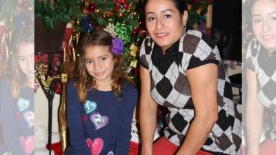 La niña hondureña Ligsdenis Ochoa, acompañada de su madre Jessica, posa en su vivienda de Charlotte.