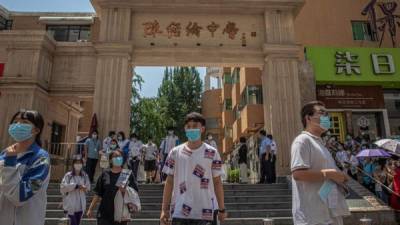 Los estudiantes con mascarillas dejan una escuela después de realizar su examen durante el primer día de los exámenes anuales de ingreso a la universidad nacional de China en Pekín, China.