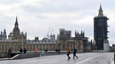 Los peatones caminan por un puente de Westminster casi desierto en el centro de Londres durante el tercer cierre nacional del nuevo coronavirus. Foto AFP