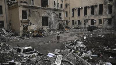 Un militar ucraniano camina entre los escombros de la sede regional destruida de Kharkiv.