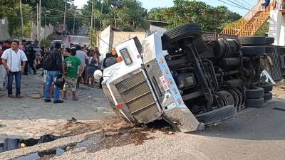 El camión tráiler que transportaba a migrantes por el sur de México yace de costado después del accidente.