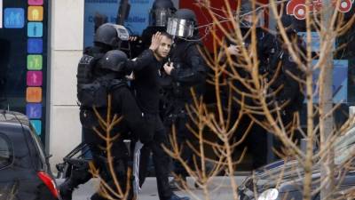 El hombre que había tomado dos rehenes en una oficina de correos fue arrestado por agentes de policía. AFP