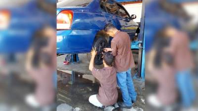 Jóvenes en práctica de mecánica automotriz.