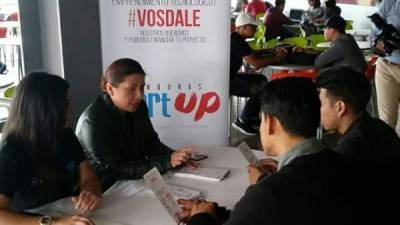Dos universitarios reciben instrucciones sobre la competencia Honduras StartUp.